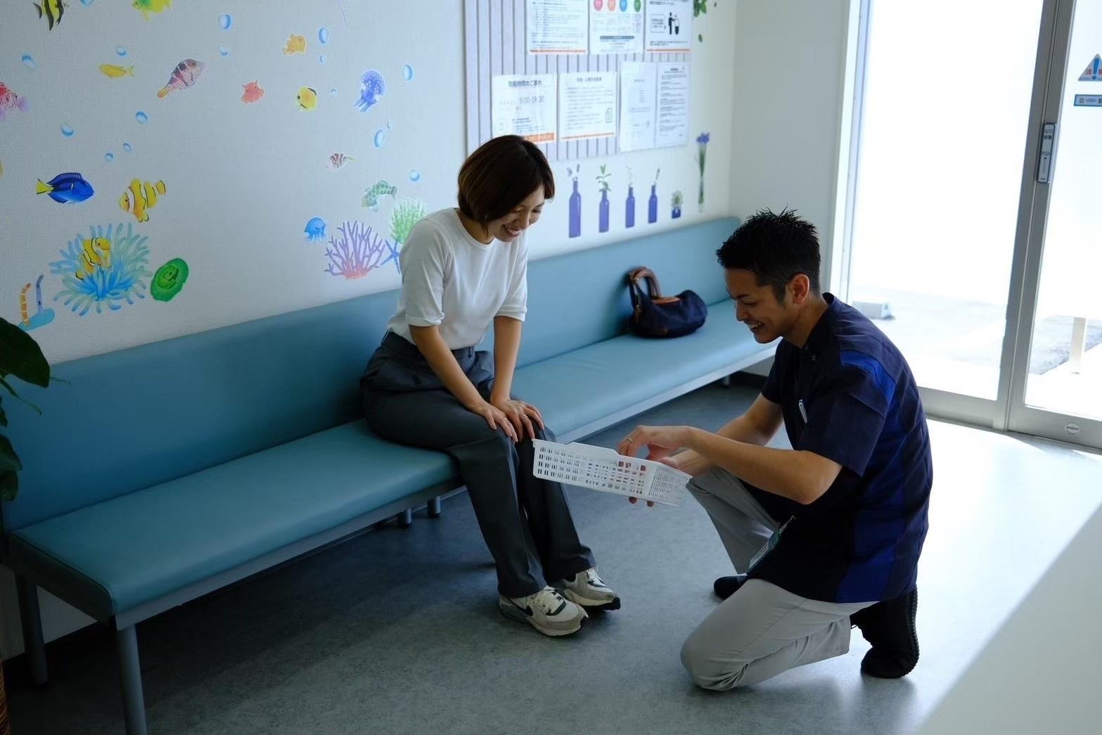 待合スペースで来局者と会話する薬局長