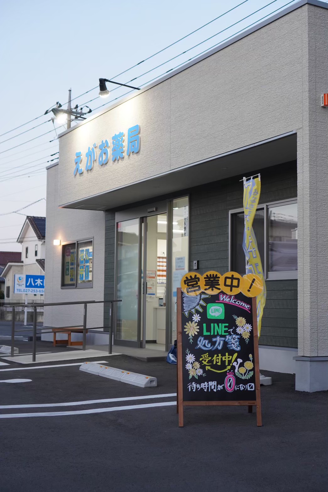 夕方のえがお薬局の店舗と駐車場